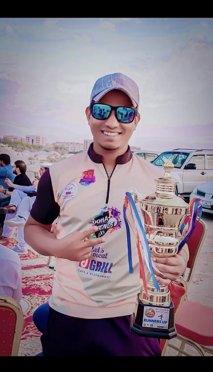 Habib in a white jersey holding a trophy