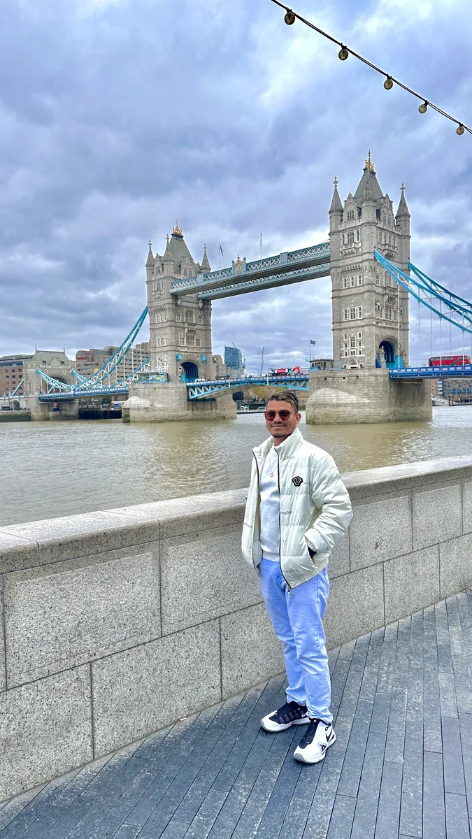Habib in a white jacket in front of Tower Bridge, London